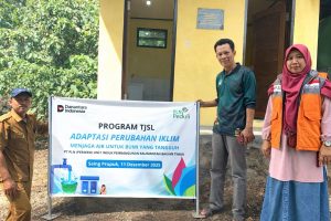 PLN UIP KLT bersama perangkat desa dan masyarakat menunjukkan papan program TJSL “Adaptasi Perubahan Iklim – Menjaga Air untuk Bumi yang Tangguh” di Desa Saing Prupuk, Kecamatan Batu Engau, Kabupaten Paser, Kalimantan Timur.